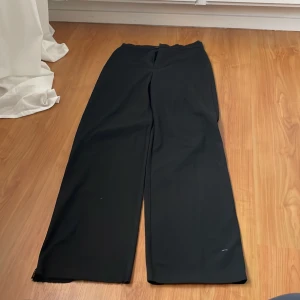 Svarta vida byxor - Snygga svarta byxor med en vid passform. Perfekta för en stilren look. Byxorna har en hög midja och är tillverkade i ett mjukt material som ger en bekväm känsla.
