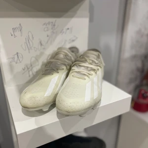 Adidas crazy fast  - Snygga beige fotbollsskor från Adidas med vita detaljer och snörning. Perfekta för fotbollsplanen med en stilren design och bra grepp på sulan.