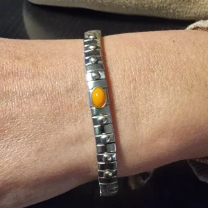 Stretcharmband  - Stretcharmband i rostfritt stål och guld med naturliga hårda stenar.  Bredd: 0,7 cm.  Tillgängliga storlekar: Stretcharmband i rostfritt stål och guld med naturliga hårda stenar.