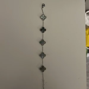 Armband med fyrklövermotiv - Elegant armband med flera fyrklöverformade länkar i en grön nyans. Perfekt för att ge en touch av stil och tur till din outfit. Armbandet har en smidig kedja och en säker låsning.