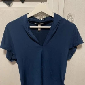 Mörkblå v-ringad topp från H&M - En fin topp ifrån H&M som inte kommer till användning. Den har en v-ringning och är kort i armarna, mycket bra skick!🤗