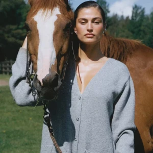 Grå stickad kofta - Superfin och mysig tröja från Bikbok. Koftan har en v-ringad design med knappar framtill och ribbade muddar. Perfekt för en stilren och bekväm look. Nästan aldrig använd. Nypris 499kr