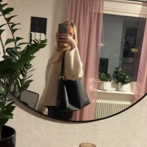 Svart axelväska från Bik Bok - Snygg svart axelväska från Bik Bok i stilren design. Perfekt för att bära med sig det nödvändigaste. Väskan har en enkel och elegant look som passar till många olika outfits.