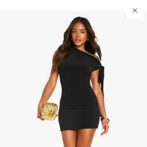 Svart oneshoulder klänning - Kort svart klänning med knytning. Endast andvänd en gång! Säljer då den inte kommer till andvändning. 