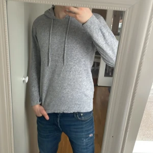 Grå merinoull hoodie - Säljer en stilren grå merinoull hoodie. Den har ett hål under armhålan men den kan lätt sys igen!