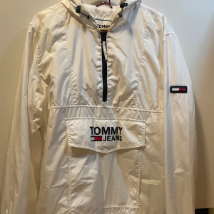 Jacka Tommy Hilfiger - En vit  windbreaker/vindjacka av Tommy Hilfiger i strl s                                                                                            Den är använd väldigt få gånger då den har bara legat i garderoben. Inga defekter på den, fortfarande stilren och passar med hundratals outfits!