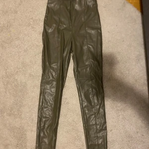 Gröna skinnbyxor - Snygga gröna skinnbyxor med hög midja och tight passform. Perfekta för en trendig look med en cool känsla. Byxorna har en slät yta och är designade för att sitta bekvämt hela dagen.