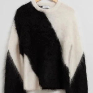 Other stories tröja - Säljer en supermjuk och fluffig tröja från & other stories i svart och vitt. Tröjan har ett diagonalt mönster och långa ärmar. Perfekt för att hålla sig varm och stilren under kyliga dagar. Passar perfekt till jeans eller kjol för en trendig look.