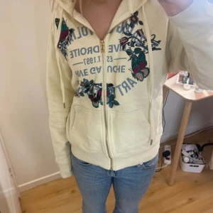 Jättefin beige hoodie från Zadig & Voltaire - Säljer en snygg beige hoodie från Zadig & Voltaire med dragkedja och blommigt tryck i flera färger, tror inte det står storlek i men passar mig som brukar ha xs-s nypris 3000 och  pris kan diskuteras. Finns några pyttesmå fläckar på men som verkligen inte syns när man har den på sig💗