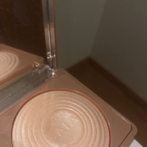 Highlighter från CAIA - Snygg highlighter från CAIA i en elegant kompakt förpackning. Den har en skimrande finish som ger en strålande glöd. Perfekt för att framhäva kindben och andra ansiktsdrag.