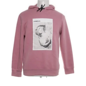 Rosa hoodie från H&M med tryck - Säljer en rosa hoodie från H&M med ett konstnärligt tryck på framsidan. Hoodien har en justerbar huva med snörning och är tillverkad i en mjuk bomullsblandning. Perfekt för en avslappnad stil.