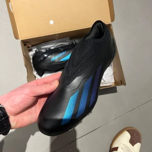 ADIDAS X CRAZYFAST.1LACELESS FGNIGHTSTRIKE - SVART - I have several sizes of Professional football boots ADIDAS X CRAZYFAST 1 LACELESS FG NIGHTSTRIKE - SVART. New Condition! They fit snugly and are made from synthetic material for optimal performance, a good option for the season!