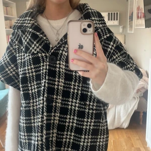 Rutig kappa - Så cool och unik kappa! Den har korta ärmar och en luva där bak. Man kan både ha den knäppt eller uppknäppt som man ser på de första bilderna. Inga tecken på användning!🖤