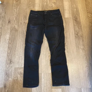 Svarta jeans från Jack & Jones - Säljer ett par svarta jeans från Jack & Jones, modell Comfort/Mike. Storlek W29:L30De är i ny skick och har en bekväm passform. Köpta för 900kr. Perfekta för både vardag och fest! 🖤