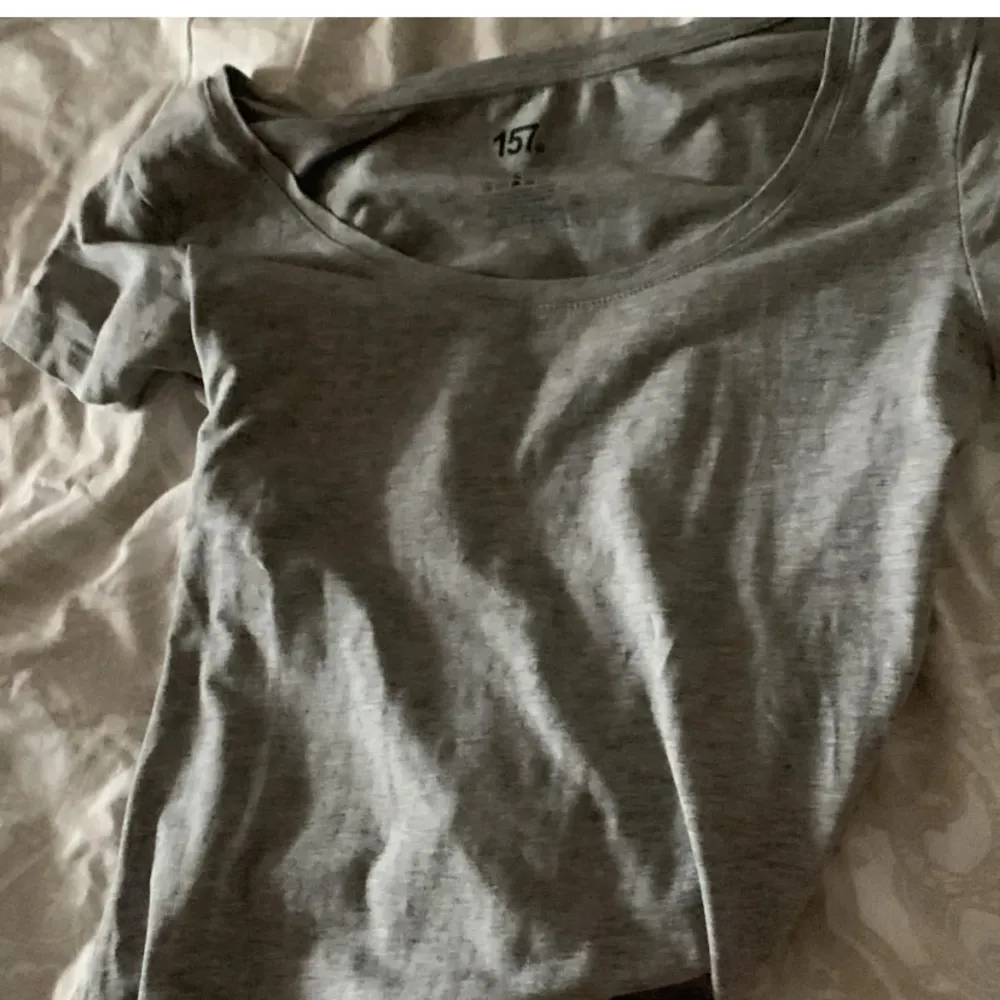 Säljer en enkel och stilren grå t-shirt från 157. Den har en normal passform och korta ärmar, perfekt för vardagsbruk. Materialet känns mjukt och bekvämt mot huden. Passar bra till jeans eller shorts för en avslappnad look.. Toppar.