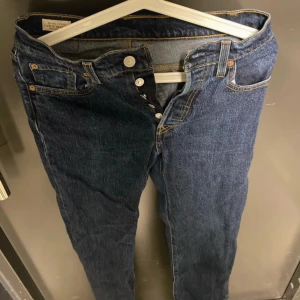 Levi's Premium Jeans - Säljer ett par snygga Levi's Premium jeans i mörkblå denim. De har en klassisk femficksdesign och knappar i gylfen. Perfekta för både vardag och fest! 🕺