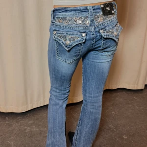 Lågmidjade jeans  - Lågmidjade bootcut jeans med snygga paljett fickor!!!✨✨ Innerbenslängd: 75cm Midja: 28x2  Modellen är 164 cm lång 