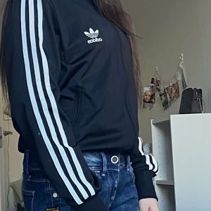 Adidas kofta - Säljer denna snygga adidas tröjan. Den är köpt för ungefär 5 år sedan men är i mycket bra skick då den inte är så använd. Den är i storlek 40 men passar även om du har stl Xs som hon på bilden. Budgivning börjar på 200 inkl frakt.