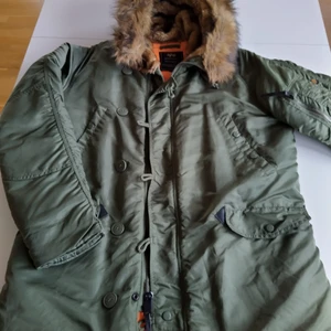 Alpha Industries Parkas N3B XL - Grön, orange foder, huva med fuskpäls på insidan, varmfodrad, 4 fickor + ärmficka + innerficka, knappt använd, mycket fint skick
