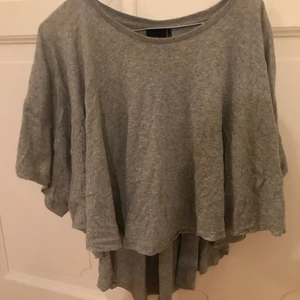 Flowig tröja Urban Outfitters - Grå flowig tröja från Urban Outfitters i storlek xs, lång där bak och kortare där fram! Oanvänd!🤎