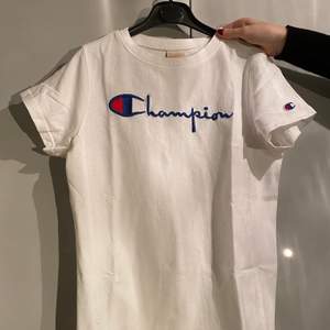 Snygg vit t-shirt från Champion, knappt använd. Passar både tjejer och killar.