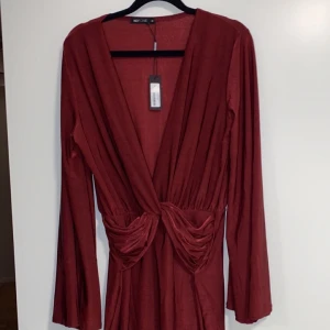 klänning, storlek M - Väldigt fin vinröd klänning. Den är oanvänd bara testad, prislappen sitter kvar. Tyg som markerar midjan och lite utsvängda armar