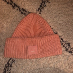 Acne Mössa - Säljer min rosa acne mössa. Den är i ett rätt använt skick så där av det rätt billiga priset. (Nypris 1200 kr)  Kontakta mig privat eller i kommentarerna för mer info!