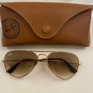 Solglasögon RayBan - Solglasögon från RayBan i deras klassiska pilotmodell. Storlek Small. Fint skick. Självklart äkta, köpta för 1.700kr. Kan mötas upp i Stockholm eller fraktas, man får med fodral. 🥰