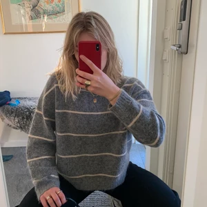 Acne Studios Mohair Striped Sweather - Fin stickad tröja från Acne i mohair- och ullblandning i absolut nyskick!!!! Grå med beiga/benvita ränder. Storlek S men passar allt från 36-40 beroende på önskad passform. Jag är en 36/38. Verkligen superfin, men inte kommit till användning. Nypris 3000:-