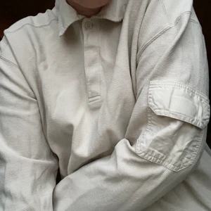 TRÖJA  - Beige långärmadtröja i nyskick! Storlek L. Knäpps med kardborre och en knapp vid halsen. Första och sista bilden återger färgen bäst. Katt finns i hemmet och frakt tillkommer. 