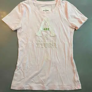 T-shirt från Abercrombie and Fitch i storlek XS. Den har en liten gul fläck på magen men kan nog gå bort i tvätten.