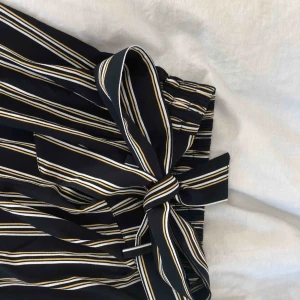  - Superfina och sköna kostymbyxor med snörning från Bikbok. Modellen har vida ben och resår bak vid ryggen vilket gör att byxan sitter mycket fint. Storleken är XS men passar även S och M Köparen står för frakt