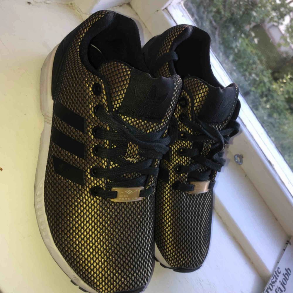 Guld och svarta skor från adidas | Plick Second Hand