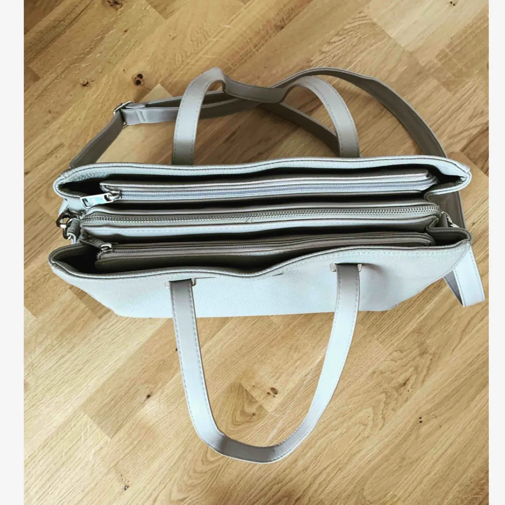 Rymlig handväska i en grå färg med justerbart samt avtagbart axelbandsrem och 3 rymliga fack med väl fungerade dragkedjor 🐚 Tveka inte på att höra av dig vid funderingar ✨. Väskor.
