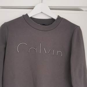 grå Sweatshirt från Calvin Klein i strl XS. Fin och hel, inga fläckar men lite nopprig vilket syns på sista bilden, men inget som syns mycket eller stör. Fraktkostnaden är inte inräknad i priset, köparen står för frakt. Betalas via swish. Hör av dig vid frågor :)