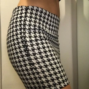  - Kort kjol i hundtandsmönster. Stretchigt tyg