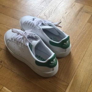  - Stan Smiths med högre sula strl 40. Använda en gång och säljes pga för små. Snörerna fortfarande helt vita och det syns endast på sulan att dom vart ute en gång.  Orginalpris 1100kr