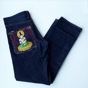 Helt nya jeans av ökänt märke. Ascoola fickor med broderat motiv. Mått: midja, 44 cm rakt över, längd, 114 cm. Frakt: 56 kr.