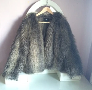  - Pälsjacka(fake såklart) som är perfekt nu när det är kallt! Man knäpper jackan med 2 hylsor. Jackan har 2 funktionella fickor i på sidan. 
Nyskick! 