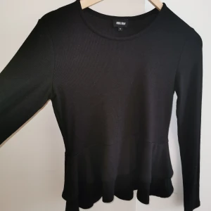 Svart tröja med en utvängd nederdel🖤 - Säljer denna svarta tröja i storlek M, med en härlig utsvängd nederdel som ger tröjan det lilla. Använd endast en gång, tyvärr passar den inte mig så den behöver en ny ägare. 🖤