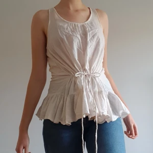 Vollangtopp från Gina - Supersöt vollangtopp från Gina i 100% bomull. Har en mycket justerbar midja. Är i storlek 34. Går att få den större men sitter nog bäst på någon med runt storlek S. Säljer för 49kr exklusive frakt (44kr). Bjuder dock på frakten vid köp över 300kr. Skriv i dm vid intresse eller för frågor! 