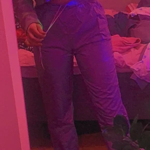 Jättejättefina trackpants från adidas! - Jättefina lila trackpants köpta second hand men från adidas! Färgen syns bäst på bild 2! Detta var mina favoritbyxor länge men har tröttnat, väldigt 80 tal! Långa på mig som är ca 165 och har dragkedjor nere som man kan dra upp och ner! Snören på insidan i midjan som man kan dra åt! 100kr + 44kr frakt = 144kr!