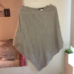 Stickad poncho  - Säljer en stickad grå poncho som aldrig blivit använd! Vid fler bilder om tex passform, kontakta mig i chatten så ska jag försöka lösa de! 