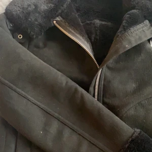 Jacka från HM - En mysig svart jacka från HM. Jackan har mysigt päls innuti och längst armarna. Väl använd därav billigt pris. OBS!! Jackan är svartare än på bilden! 