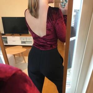Nelly Velvet Body - Så fin julröd body från Nelly, använd ca. 3 gånger. Den har djup rygg och är i fint skick som ni kan se på bilden. Perfekt för jul/nyår!