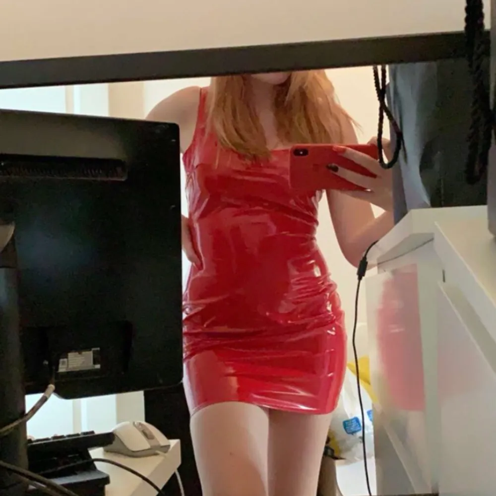 En röd klänning i glansigt och stretchigt material. Oanvänd, endast testad av min kompis (hon på bilden) skulle säga att den passar 36-38. Klänningar.