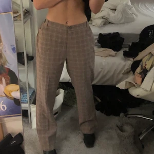 Beiga kostymbyxor - Skitsnygga beigerutiga kostymbyxor! Raka i modellen. Har tyvärr inte kommit till användning:/    (psst de 2 sista bilderna har lite gult ljus men på första ser man färgen) skriv om ni vill ha tydligare bilder