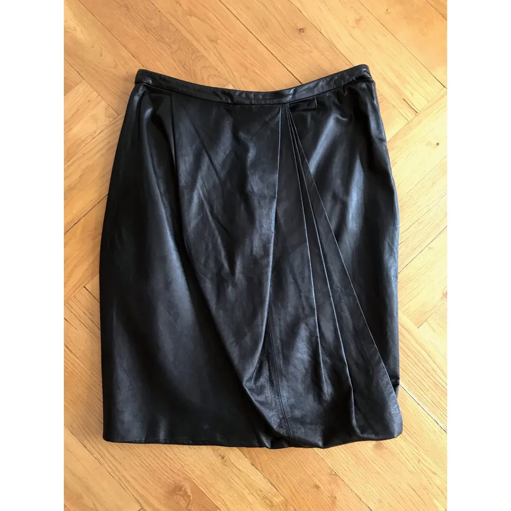 Acne Moholy leather skirt from the Spring/Summer 2009 collection. Draped pleating, button closure and concealed side zip, size 36.. Klänningar.