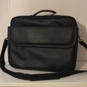 Axelremsväska - I fejkläder. Mest hängt i garderoben och är inte sliten. Ingen tappad färg. 