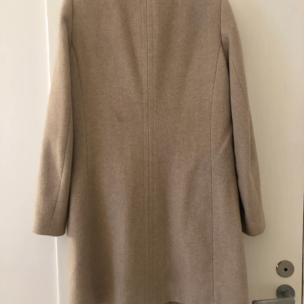 Beige kappa från Mango, stl 36. Fint skick! Hög krage som går att knäppa, detalj på kragen. Frakt ingår i priset . Takit.